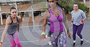 Diverse female basketball team playing match, dribbling ball