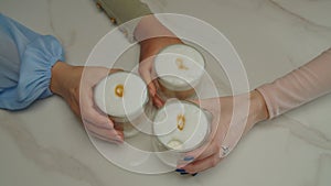 Diverse female hands taking cups hot cappuccino coffee