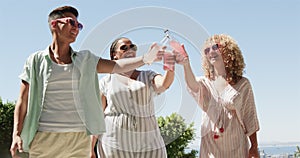 Diverse friends celebrate outdoors with a toast