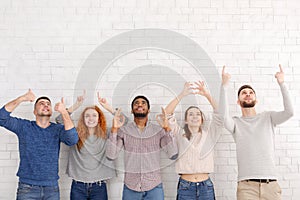 Diverse friends gesturing with hands over white wall