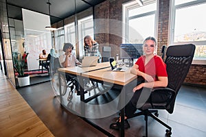 A diverse group of business professionals collaborates in a modern startup coworking center, utilizing a mix of paper