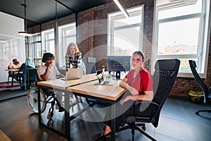 A diverse group of business professionals collaborates in a modern startup coworking center, utilizing a mix of paper