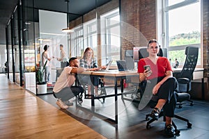 A diverse group of business professionals collaborates in a modern startup coworking center, utilizing a mix of paper