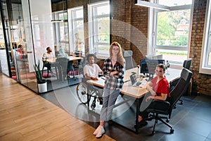 A diverse group of business professionals collaborates in a modern startup coworking center, utilizing a mix of paper