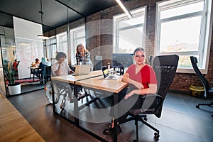 A diverse group of business professionals collaborates in a modern startup coworking center, utilizing a mix of paper