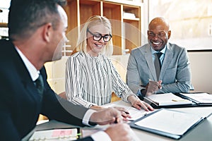 Diverse group of businesspeople laughing during an office meetin