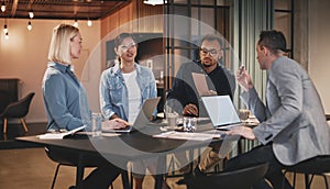 Diverse group of businesspeople talking together in an office