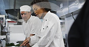 Diverse group of chefs standing around a table listening to instructions