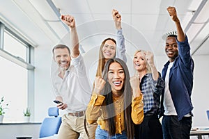 diverse group of colleagues cheering together in office