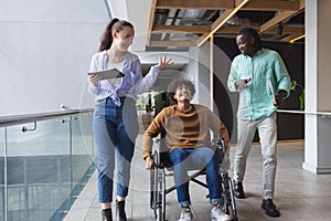 Diverse group of colleagues walking and talking in a modern business office hallway