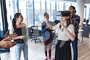 Diverse group of creative colleagues talking at meeting using vr headset