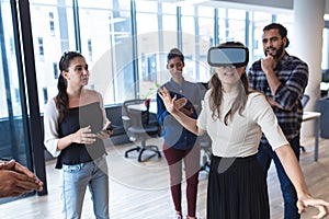 Diverse group of creative colleagues talking at meeting using vr headset