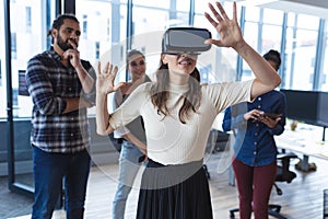 Diverse group of creative colleagues talking at meeting using vr headset