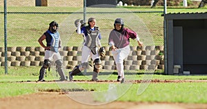 Diverse group of female baseball players playing on the field, happy hitter hitting ball and running