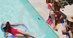 Diverse group of female friends having fun at pool bouncing ball