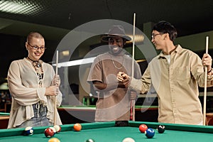 Diverse Group of Friends Enjoying Game of Pool Together