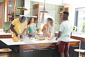 Diverse group of friends preparing food together in a modern kitchen