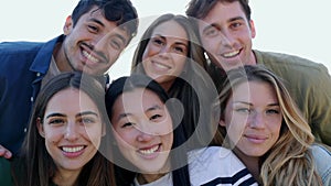 Diverse group of friends smile at camera outdoors