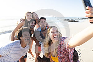 Diverse group of friends taking a selfie on the beach
