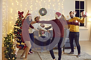 Diverse group of happy young people excited to see their friend at Christmas party