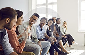 Diverse group of happy young people having discussion during business meeting or training