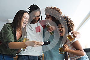 Diverse group of male and female friends looking at smartphone at bar