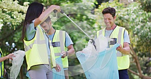 Diverse group of male and female friends putting plastic rubbish in blue refuse sacks in forest