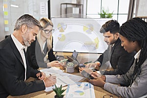 Diverse group of multiracial business people in the conference room with big TV screen