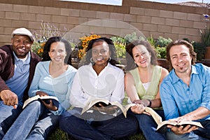 Diverse group of people reading and studying.