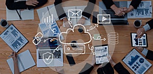 Diverse group of professionals collaborating on digital data analysis with cloud computing graphics on modern workspace