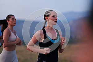 A diverse group of runners trains together at sunset.