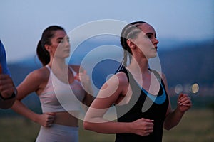 A diverse group of runners trains together at sunset.