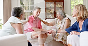 Diverse group of senior women engage in a supportive conversation indoors