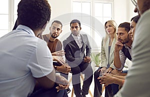 Diverse group of serious business people discussing something during meeting in office