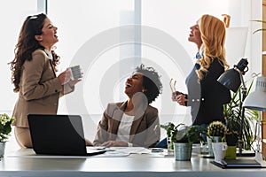 Diverse group of smiling business women having a break in office talking