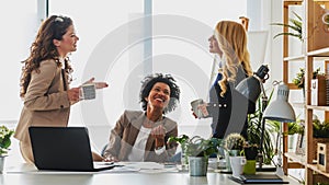 Diverse group of smiling business women having a break in office talking