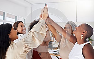 Diverse group of smiling ethnic business women giving high five after brainstorm meeting in office. Ambitious happy