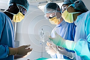 Diverse group of surgeons talking during surgery in operating theatre