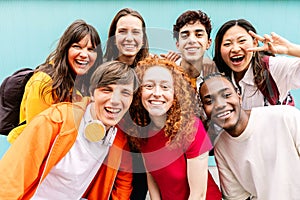 Diverse group of teenage student friends standing together over blue background
