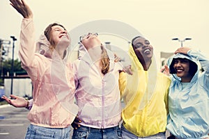 A diverse group of teenagers in raincoats outdoors