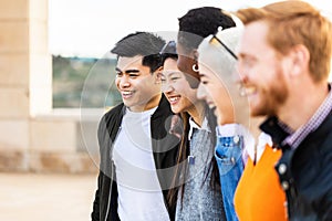 Diverse group of united young friends laughing together outdoor