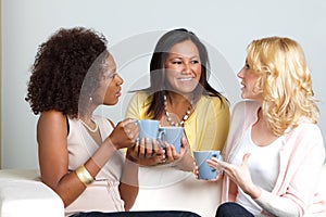 Diverse group of women talking and drinking coffee.