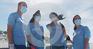 Diverse group of women wearing volunteer t shirts and face masks, talking