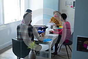 Diverse group of work colleagues wearing masks in an office