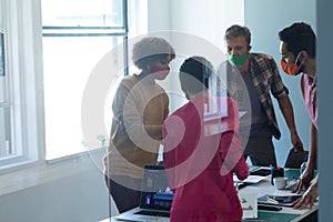 Diverse group of work colleagues wearing masks in an office