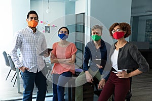 Diverse group of work colleagues wearing masks in an office