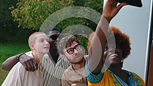 Diverse group of young adult friends camping posing for selfie together smiling and laughing. Making memories