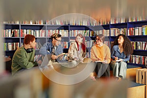 Diverse Group of Young Adults Collaborating during Study Session in Library