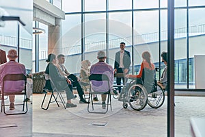 A diverse group of young business entrepreneurs gathered in a circle for a meeting, discussing corporate challenges and