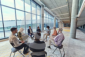 A diverse group of young business entrepreneurs gathered in a circle for a meeting, discussing corporate challenges and